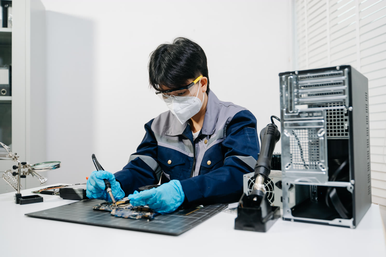 Technician performing board-level repair on laser electronics
